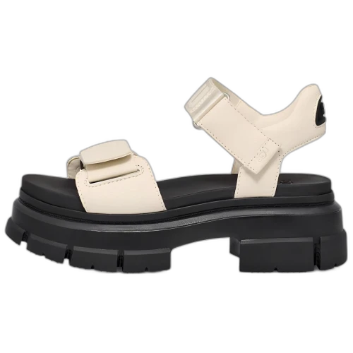 UGG Ashton Ankle Sandal Jasmine zijaanzicht met crèmekleurige bandjes en zwarte chunky zool, Velcro-sluiting