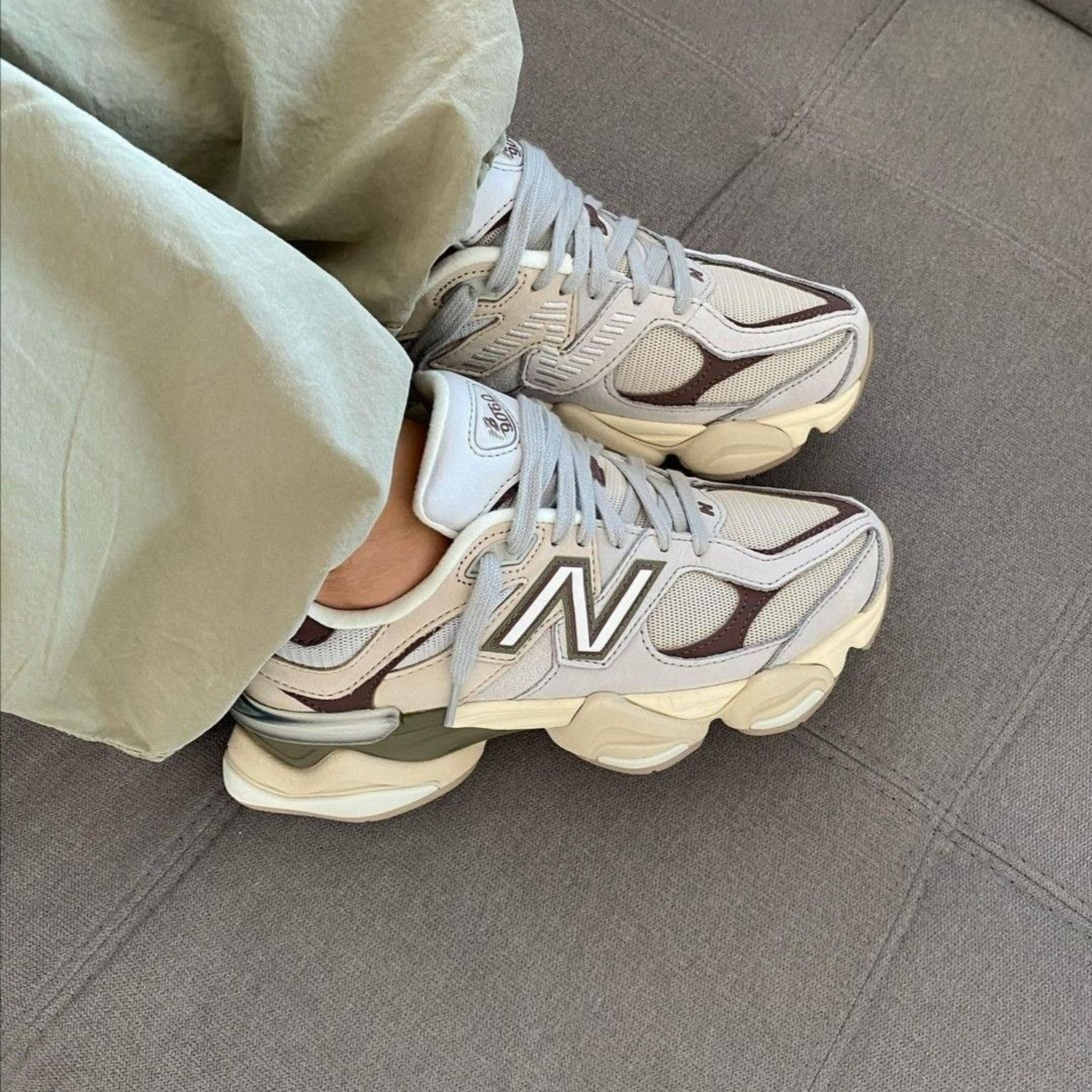 Casual feet wearing New Balance 9060 Grey Matter Timberwolf sneakers in light gray and beige tones, highlighting exclusive European style for the real deal sneaker ask.