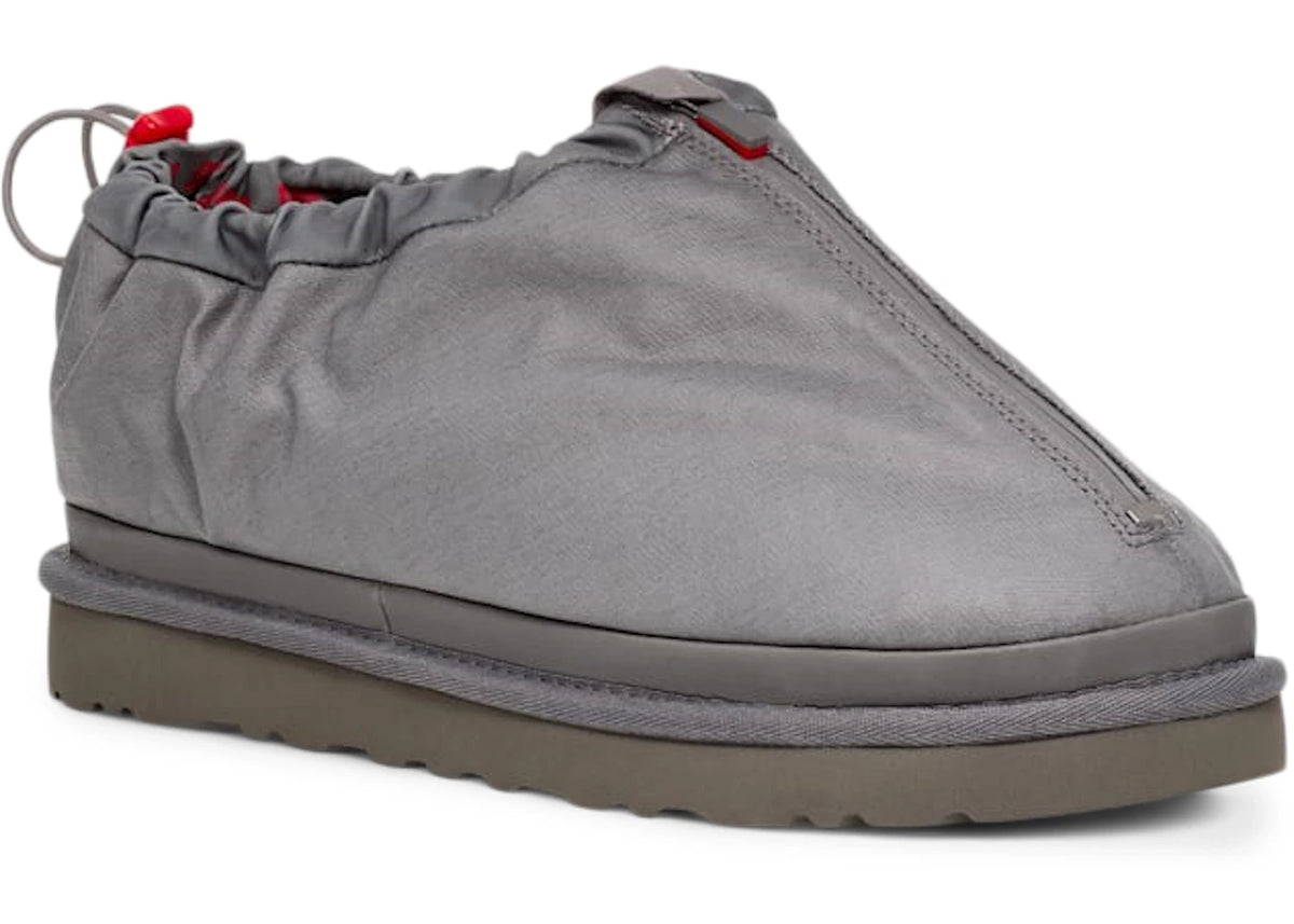UGG Tasman Shroud Zip Slipper Dark Grey, driekwart aanzicht toont grijze stof, rode details en zware grip zool