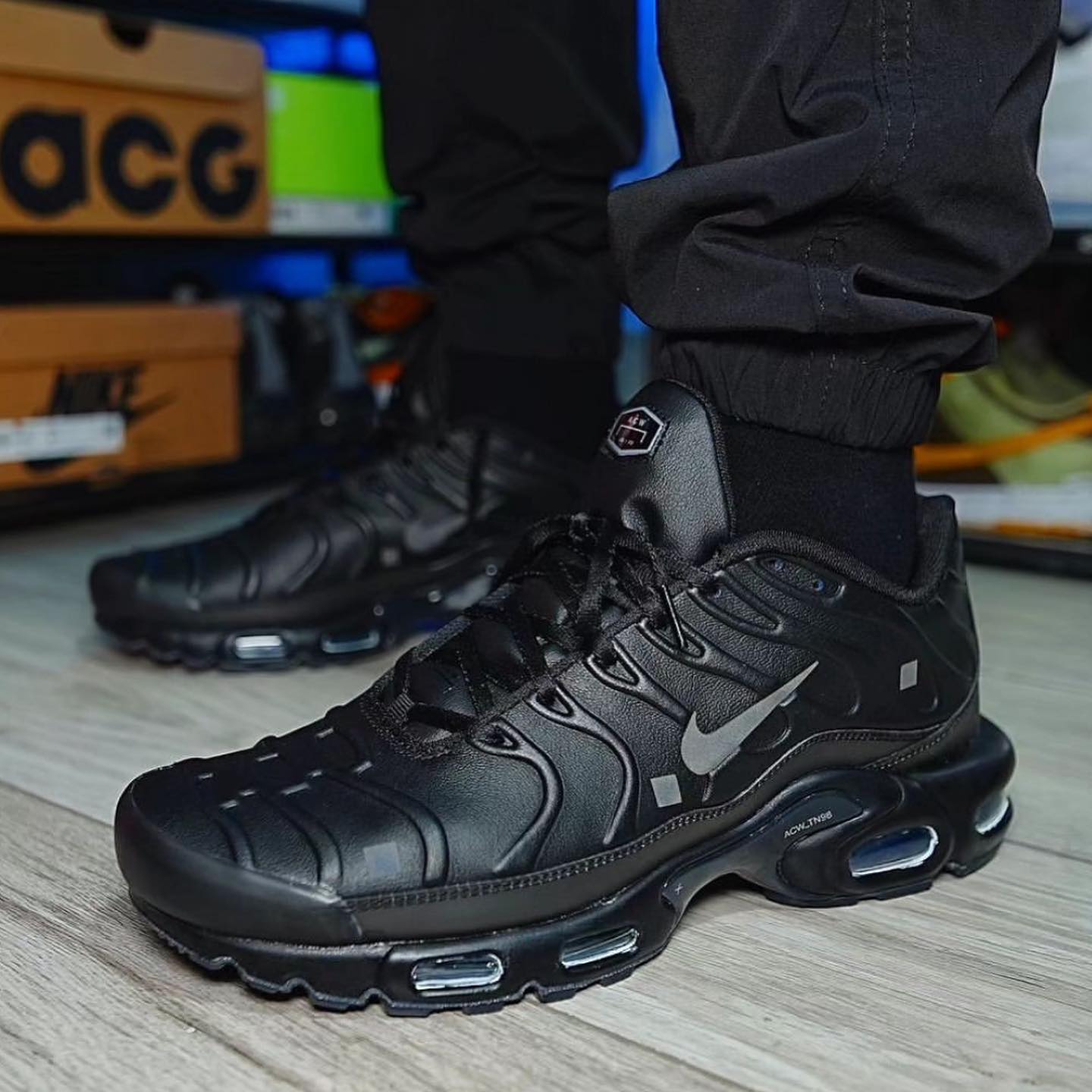 Nike Air Max Plus A-COLD-WALL Black sneakers styled with black pants, showcasing their sleek design and exclusive look. The real deal sneakers for exclusive European sneaker enthusiasts.