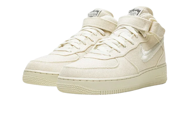Nike Air Force 1 Mid Stussy Fossil in light beige with textured fabric upper, mid-top design, and signature strap, offering exclusive sneaker style across Europe. The real deal.