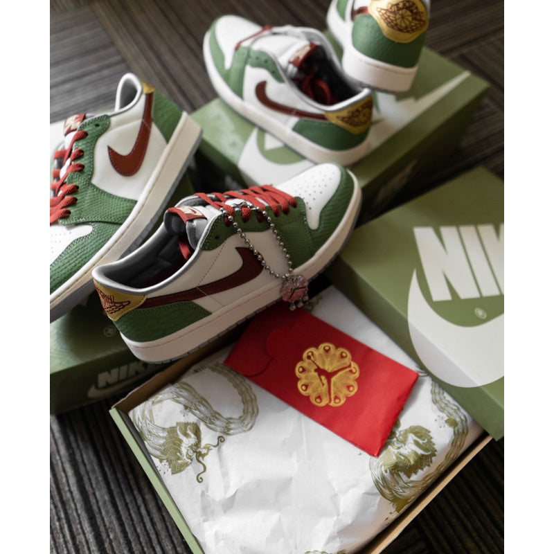Air Jordan 1 Low OG Year of the Dragon sneakers in green, white, and brown with red laces, displayed on Nike boxes with a red envelope and decorative paper, the real deal exclusive in Europe.