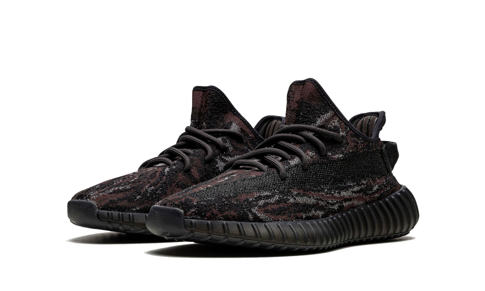 A pair of Adidas Yeezy Boost 350 MX Rock sneakers featuring a sleek black and dark brown pattern with a textured Primeknit upper and ribbed black sole, exclusive in Europe.