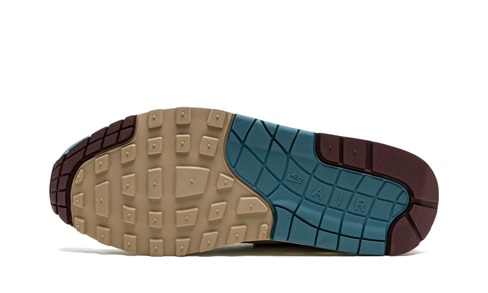 Sole view of Nike Air Max 1 Patta Waves Noise Aqua sneaker featuring beige, aqua, and dark brown rubber outsole with textured grip designed for performance and style, the real deal.