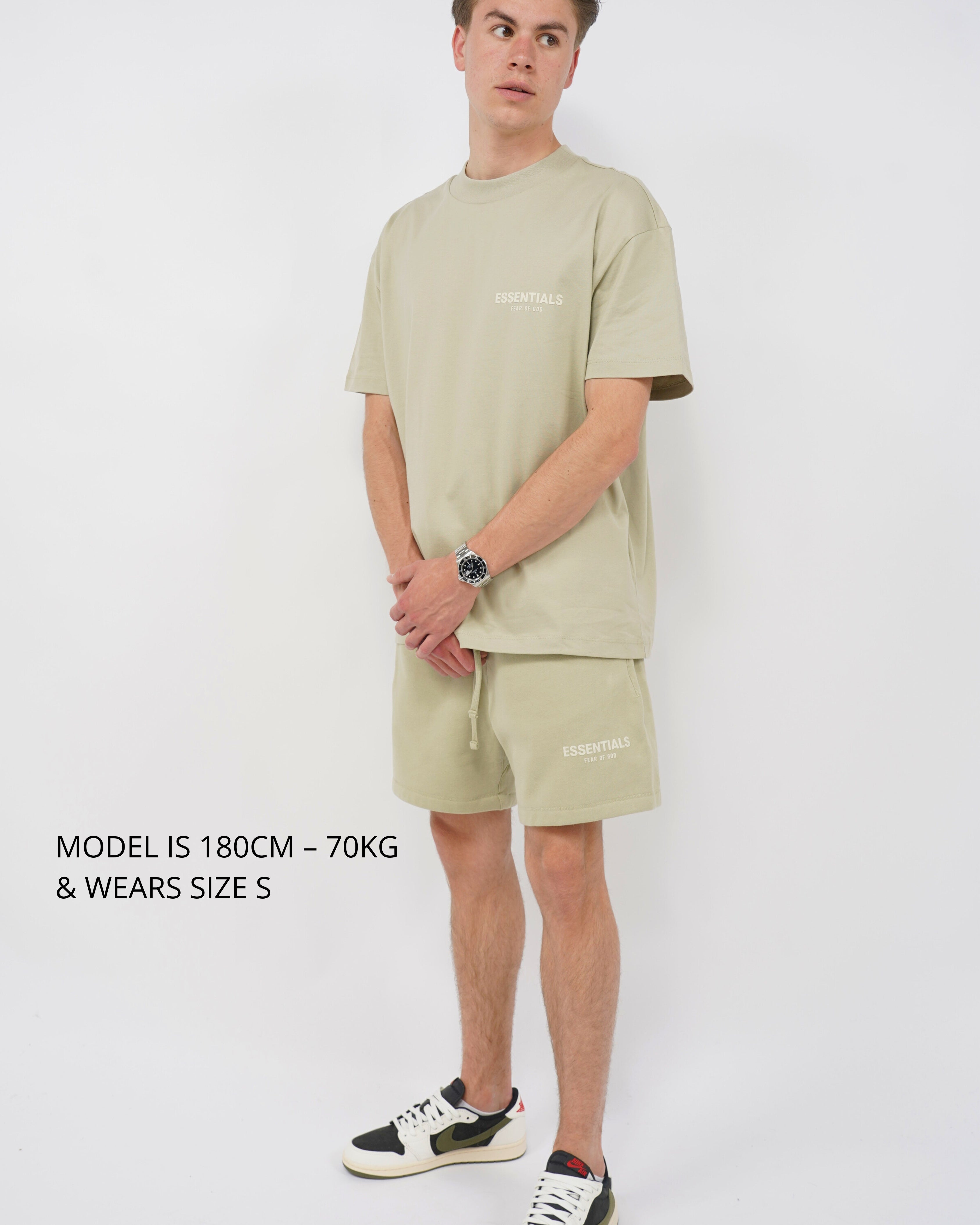 Male model wearing Fear of God Essentials Seafoam Summer set with a relaxed fit, paired with exclusive sneakers, styled for casual summer comfort, showcasing The real deal.
