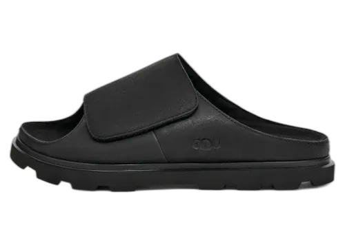 UGG Solano Slide Black, zijaanzicht van de zwarte slipper met verstelbare klittenband en diepe zoolgroef
