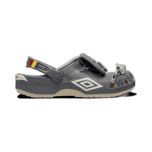 Crocs Classic Clog Umbro Bone Slate Grey, zijaanzicht met grijze body, rood-geel detail en Umbro logo