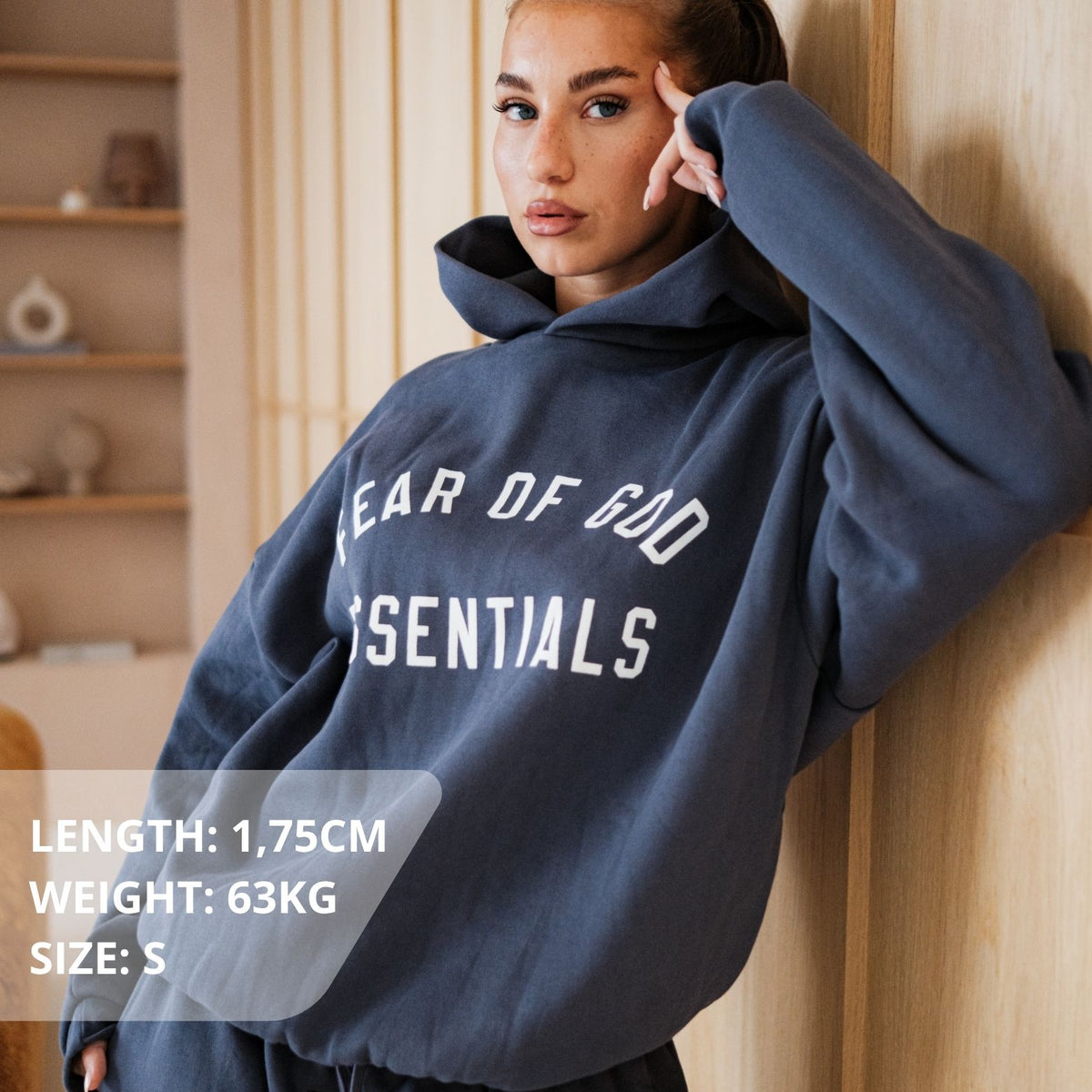 Fear of God Essentials FW24 Marine Hoodie, gedragen vooraanzicht met wit logo en zwarte binnenzijde capuchon