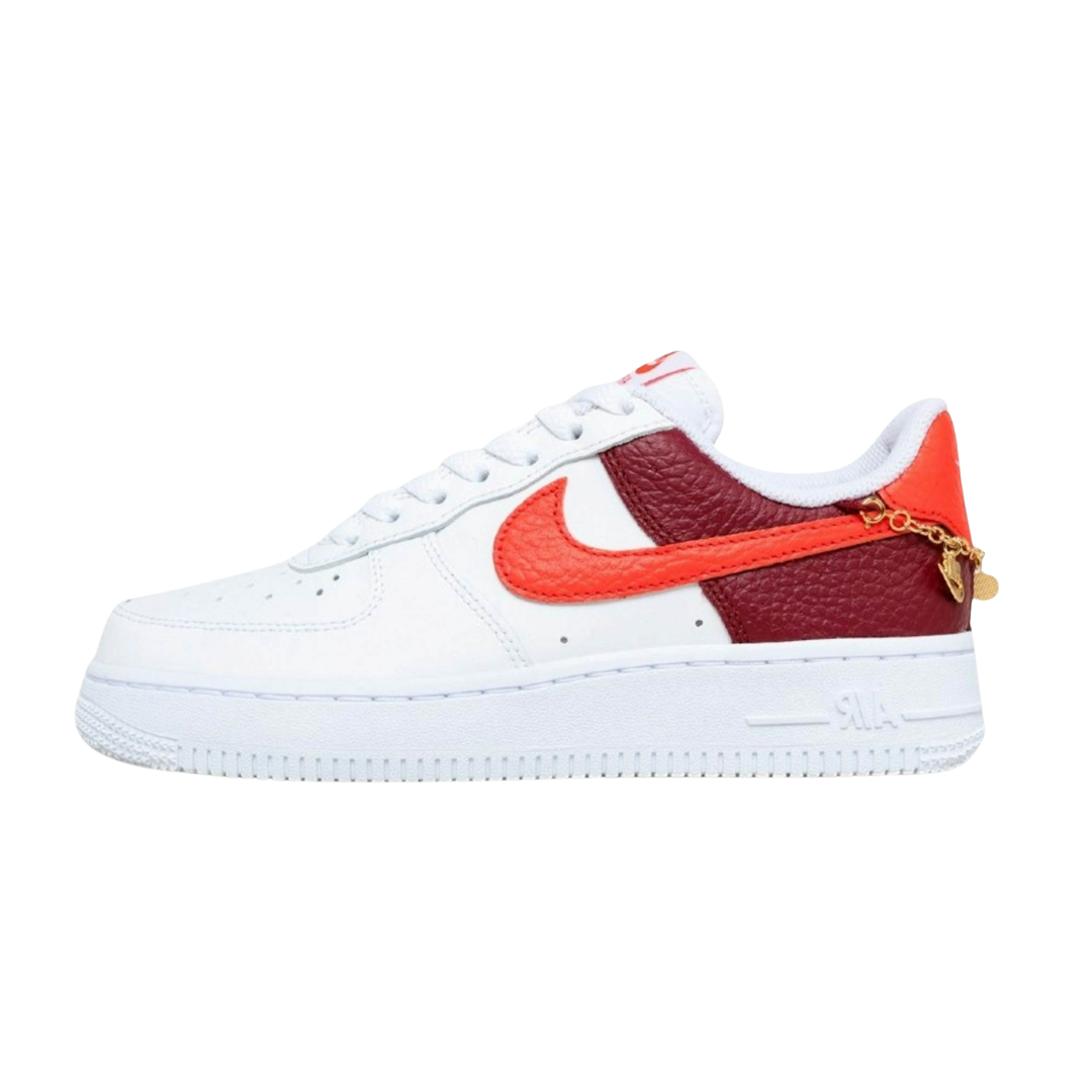 Nike Air Force 1 Low '07, zijaanzicht met wit leer, rood swoosh, bordeaux paneel en gouden charm armband