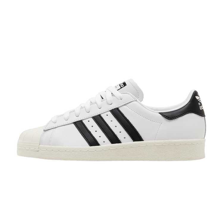 adidas Superstar 82 White Core Black, zijaanzicht met witte leren schacht, zwarte strepen en creme zool