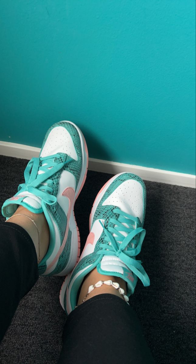 Worn Nike Dunk Low Snakeskin Washed Teal Bleached Coral sneakers with teal snakeskin pattern, white leather panels, and coral accents, styled with black pants and a shell anklet, showcasing exclusive European sneaker fashion. The real deal.