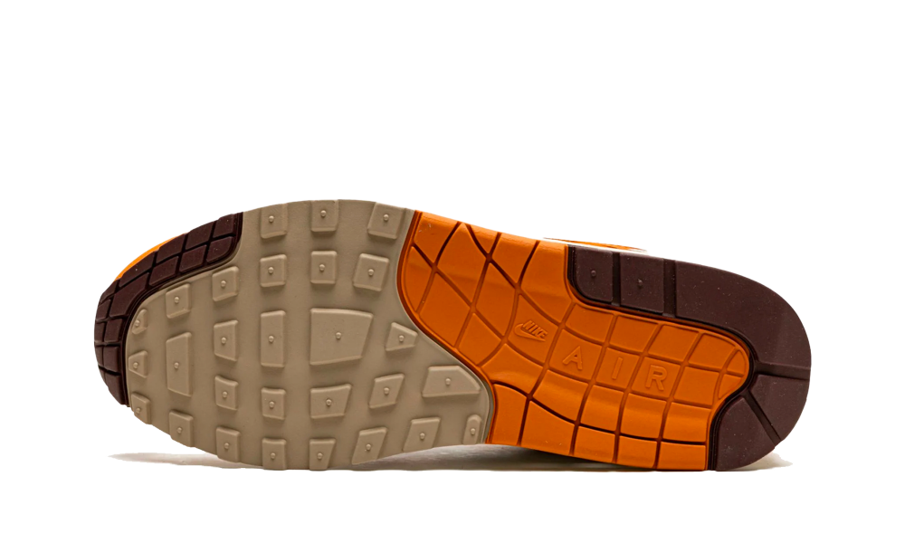 Sole view of Nike Air Max 1 Patta Waves Monarch sneaker showcasing the beige, orange, and brown traction design and exclusive sole pattern, highlighting premium trainers.